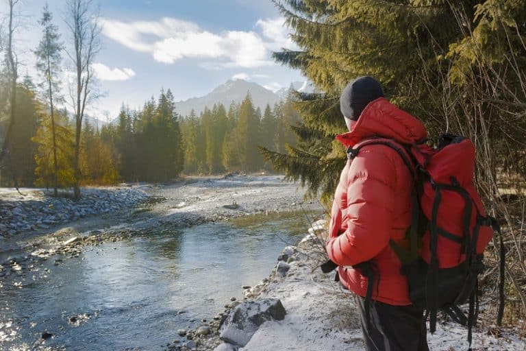 man hiking near lake