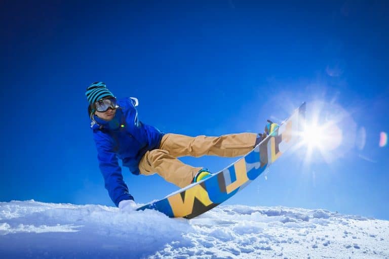 man snowboarding with style hand in the snow