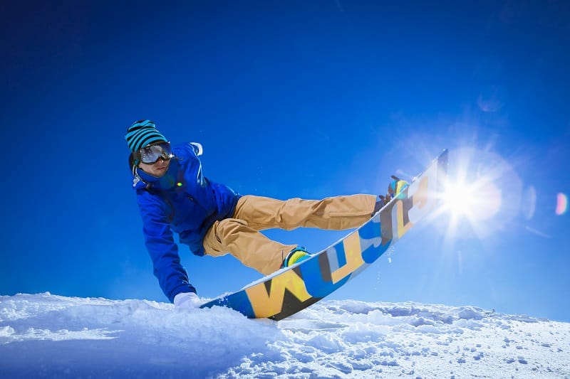 man snowboarding with style hand in the snow